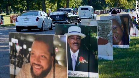 Vehicles drive past a temporary memorial for Detroit victims of Covid-19