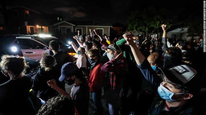 Protesters gather in front of Los Angeles County Sheriff's deputies on Monday night.