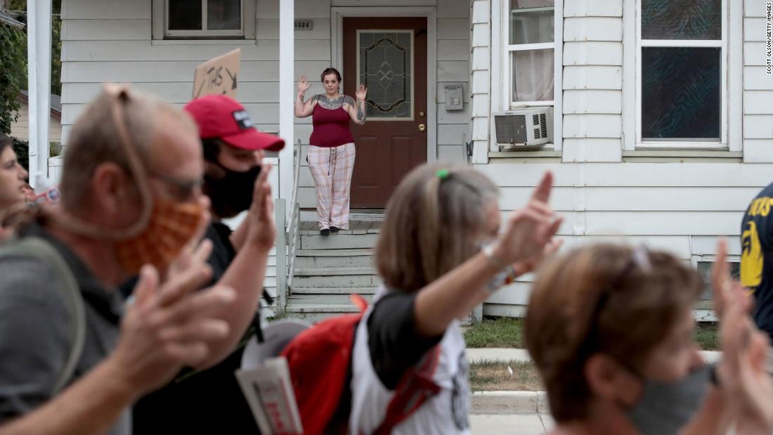 A woman shows her support as protesters march down a street in Kenosha following Trump&#39;s visit on September 1.