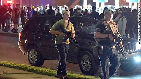 Kyle Rittenhouse, left, 17, with backwards cap, walks along Sheridan Road in Kenosha on August 25, with another armed civilian.