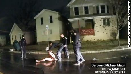 In dit beeld genomen uit politie body camera video verstrekt door Roth en Roth LLP, een Rochester politieagent zet een kap over het hoofd van Daniel Prude, op 23 maart 2020, in Rochester, New York.