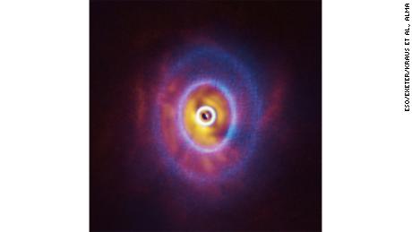 This composite image shows both the ALMA and SPHERE observations of the disk, including the rings. 