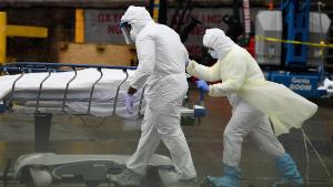 TOPSHOT - Medical personnel move a deceased patient to a refrigerated truck serving as make shift morgues at Brooklyn Hospital Center on April 09, 2020 in New York City. - America&#39;s coronavirus epicenter of New York recorded a new single-day high of 799 COVID-19 deaths Thursday but Governor Andrew Cuomo said the rate of hospitalizations continued to fall. (Photo by Angela Weiss / AFP) (Photo by ANGELA WEISS/AFP via Getty Images)