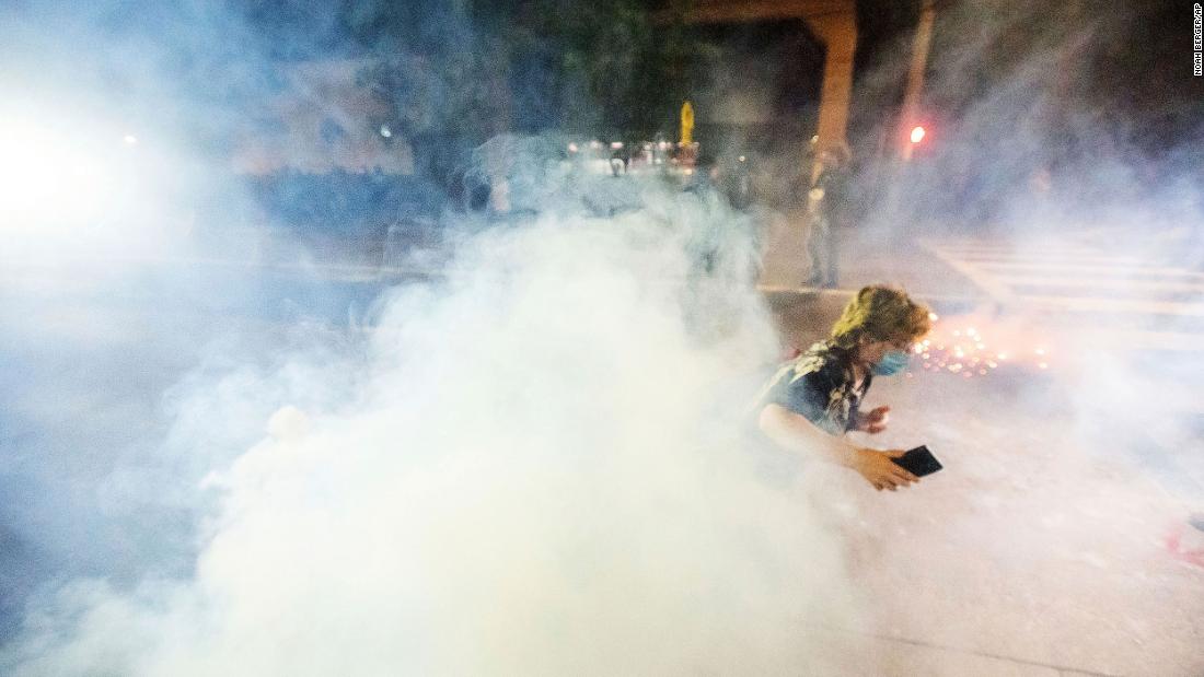 A protester runs away from chemical irritants fired by police to disperse protesters outside the Portland Police Association building on September 5.