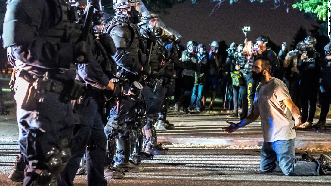 A protester holds his hands out in front of a police line during a protest on September 5.