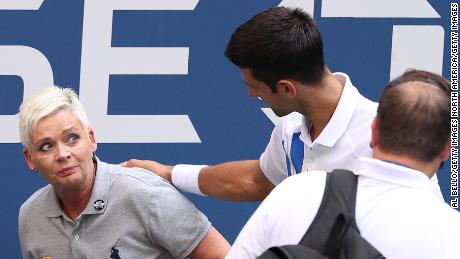 Djokovic tends to a line judge who was hit with the ball during his men&#39;s singles match against Pablo Carreno Busta at the US Open