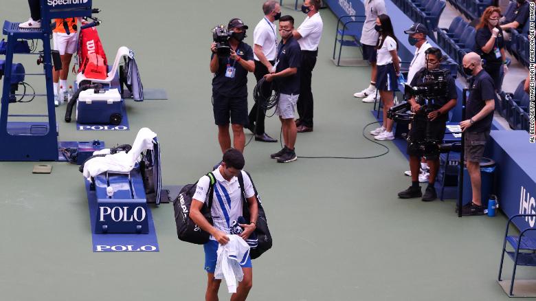 Novak Djokovic walks off court at the US Open after being defaulted. 