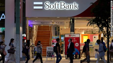 Pedestrians wearing protective masks walk past a SoftBank Corp. store in Tokyo, Japan, on Friday, Aug. 7, 2020. After reporting record losses in May and warning the coronavirus outbreak could be as devastating as the Great Depression, SoftBank Group founder Masayoshi Son is already poised to declare a recovery. Photographer: Toru Hanai/Bloomberg via Getty Images