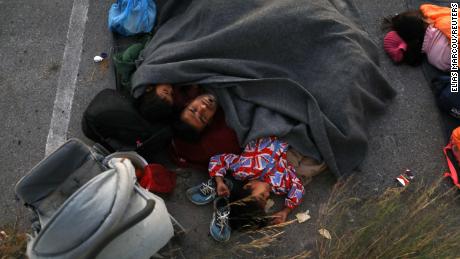 A family sleeps at a parking space, following the fire at the Moria camp.