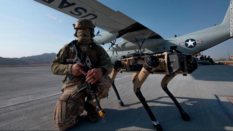 El sargento de tecnología de la Fuerza Aérea de EE. UU. John Rodiguez proporciona seguridad con un prototipo de Ghost Robotics Vision 60 durante los ejercicios en la Base de la Fuerza Aérea Nellis en Nevada.