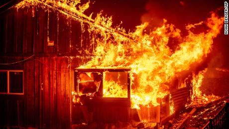 Flames shoot from a home as the Bear Fire burns through the Berry Creek area of Butte County, Calif., on Wednesday, Sept. 9, 2020. The blaze, part of the lightning-sparked North Complex, expanded at a critical rate of spread as winds buffeted the region. (AP Photo/Noah Berger)