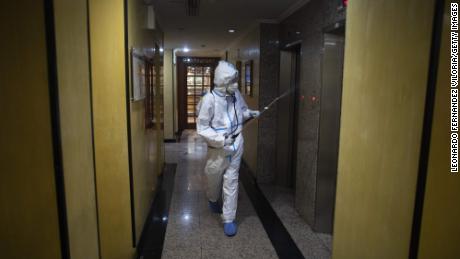 A medical workers disinfects a hotel in Caracas where suspected Covid-19 patients were staying in late July.