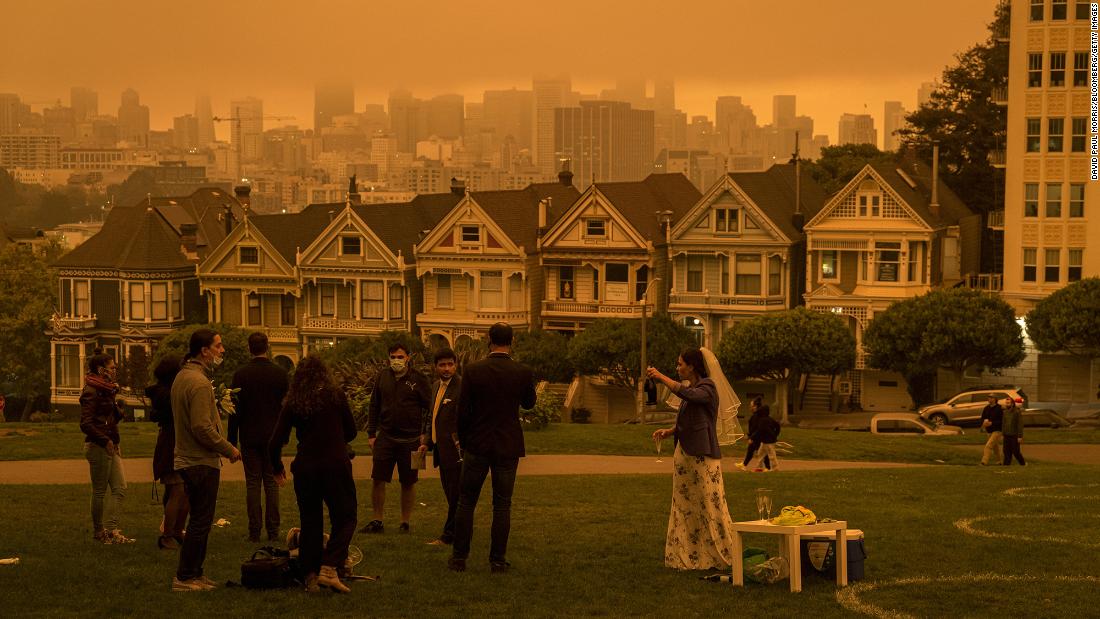 People stand in Alamo Square Park as smoke hangs over San Francisco on September 9, 2020. 