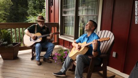 Master luthier Doug Naselroad (left) plays a tune with his mentee Earl Moore, who's holding one of 70 guitars he's made as an artist-in-residence at the Appalachian Artisan Center. 