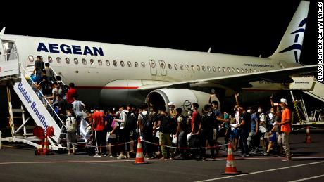 A group of children board one of three planes taking 406 unaccompanied minors from the burned camp to mainland Greece on Wednesday night.