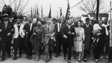 March 1965: American civil rights campaigner Martin Luther King (1929 - 1968) and his wife Coretta Scott King lead a black voting rights march from Selma, Alabama, to the state capital in Montgomery; among those pictured are, front row, politician and civil rights activist John Lewis (1940 -- 2020), Reverend Ralph Abernathy (1926 - 1990), Ruth Harris Bunche (1906 - 1988), Nobel Prize-winning political scientist and diplomat Ralph Bunche (1904 - 1971), activist Hosea Williams (1926 -- 2000). (Photo by William Lovelace/Express/Getty Images)