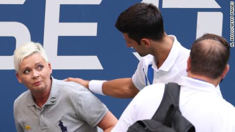Djokovic tends to the line judge who was hit with the ball.