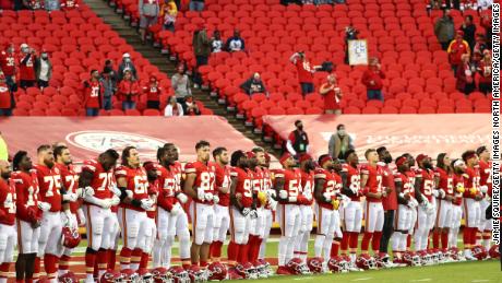 Members of the Kansas City Chiefs lock arms before taking to the field.
