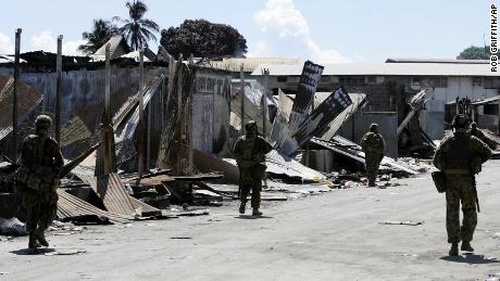 Soldados australianos patrullan el barrio chino de Honiara en las Islas Salomón el 22 de abril de 2006. Todo Chinatown ha sido prohibido como escenario de un crimen.