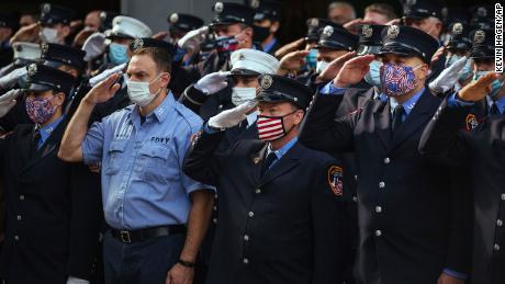 Firefighters salute in front of Ladder 10 Engine 10 near the 9/11 memorial on Friday.
