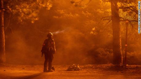 A firefighter watches flames near the Angeles Crest Highway at the Bobcat Fire north of Monrovia, California, on Friday.
