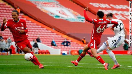 Jack Harrison of Leeds United scores his team&#39;s opening goal at Anfield as he shoots home past Liverpool defenders Trent Alexander-Arnold and Virgil Van Dijk.