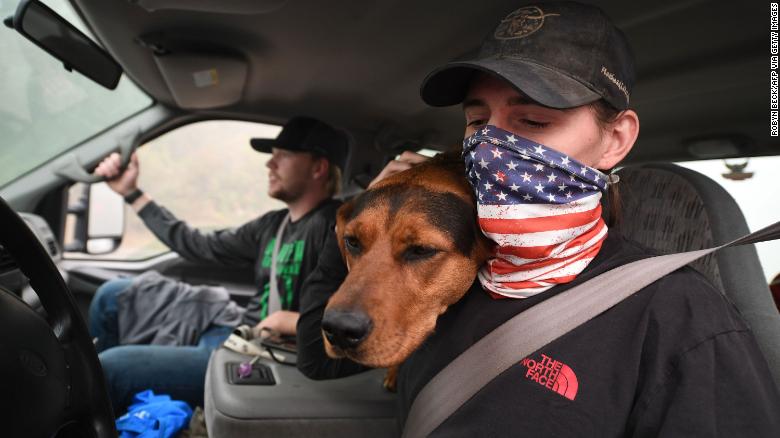 James Smith hugs his dog, Rose, after returning to his evacuated home in Estacada, Oregon, on Saturday.