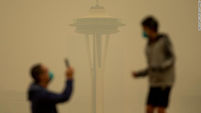 Smoke obscures the Space Needle as people take photos in Seattle&#39;s Kerry Park on Saturday. 