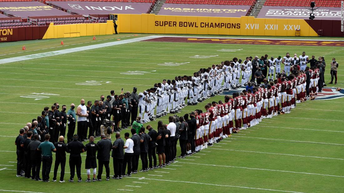The Philadelphia Eagles and the Washington Football Team stand together before their NFL season opener on September 13.