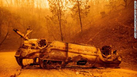 The charred remains of a vehicle are left on the side of a road during the Bear Fire, part of the North Lightning Complex.
