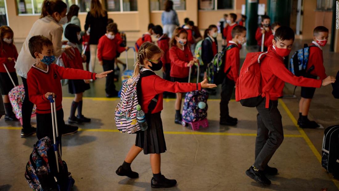 Young students make sure they are spread out from one another as they stand in a line before entering a classroom in Pamplona, Spain, on September 7.