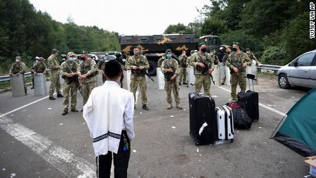 Ukrainian border guards block the road on the Belarus-Ukraine border, as more than 1,000 Jewish pilgrims tried to cross.