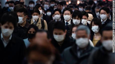 Commuters wearing face masks make their way to work in Tokyo, Japan, on March 26.