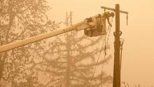 Workers continue to repair the power system after flames from the Beachie Creek Fire burned through Fishermen&#39;s Bend Recreation Site in Mill City, Oregon.