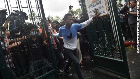 Anti-government protesters break through a gate at Thammasat University as they arrive for a pro-democracy rally in Bangkok on September 19.
