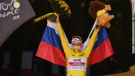 Tadij Bojacar v Sloveniji, ki je skupaj nosil rumeni vrh, slavi na stopničkah po zmagi na 107. izdaji kolesarske dirke po Franciji.