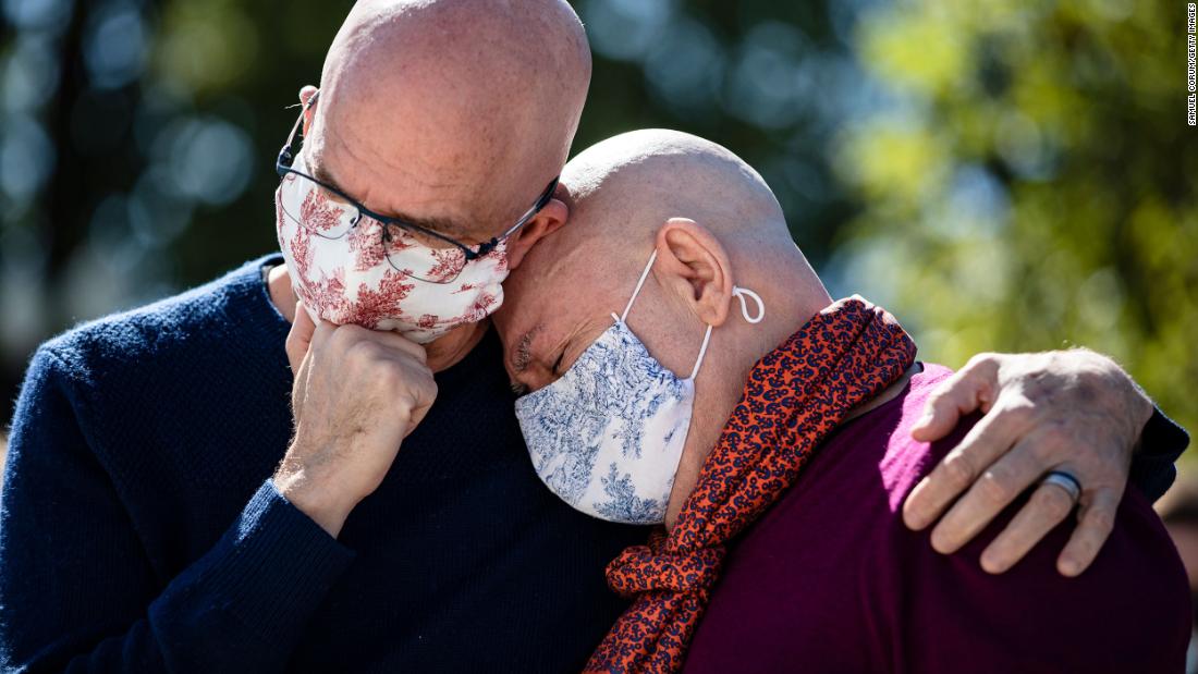 Michael Widomski, left, and David Hagedorn embrace in front of the US Supreme Court on Sunday, September 20. They had just left a photo of Ginsburg, joining them in marriage, at Ginsburg&#39;s makeshift memorial. Ginsburg officiated their wedding in 2013, two years before the Supreme Court cleared the way for same-sex marriages around the country.