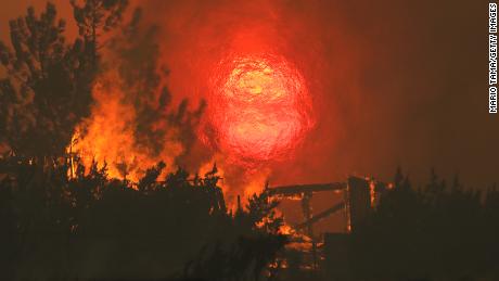  A home burns as the sun sets behind smoke and flames during the Bobcat Fire in Juniper Hills, California. 