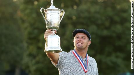 DeChambeau celebrates with the U.S. Open trophy after winning at Winged Foot Golf Club.
