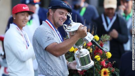 DeChambeau celebrates with the US Open championship trophy.