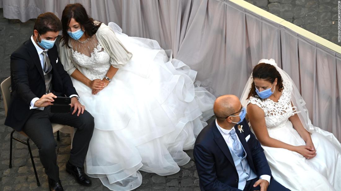 Brides and grooms wait for the Pope&#39;s arrival at the San Damaso courtyard in the Vatican on September 16.