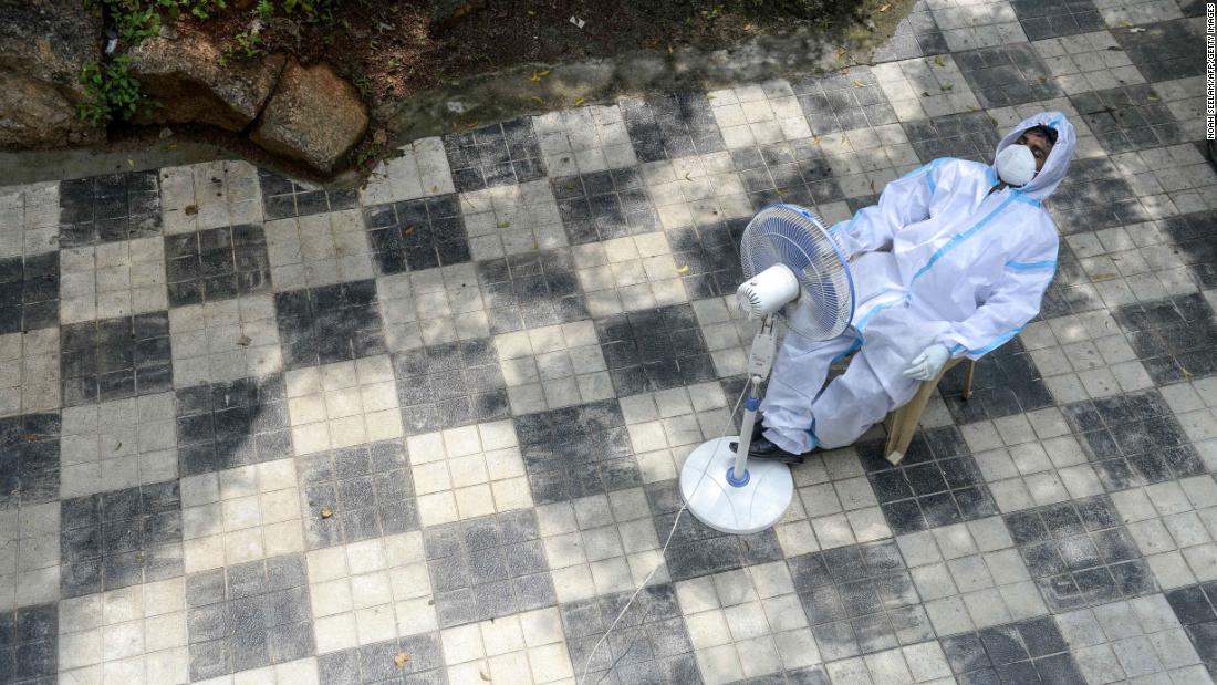 A health worker in Hyderabad, India, takes a break in front of a fan on September 17.