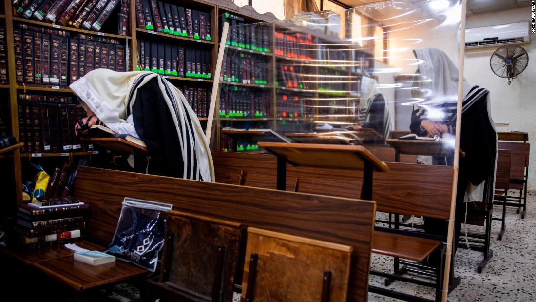 Ultra-Orthodox Jews are separated by plastic shields as they pray in a synagogue in Bnei Brak, Israel, on September 18.