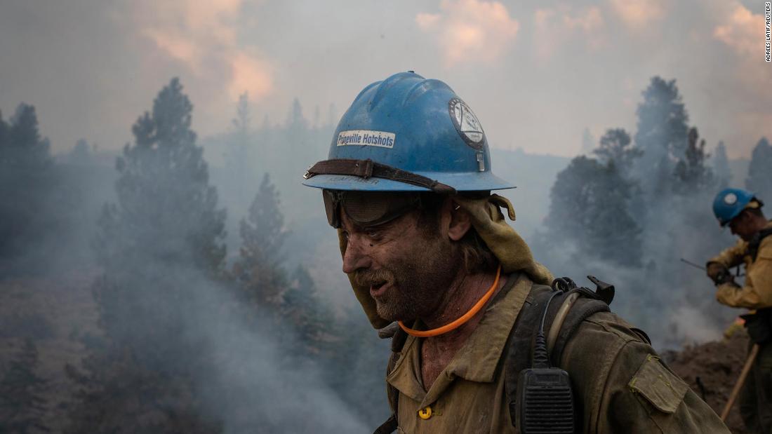 Firefighter Kirk McDusky walks past smoke rising from the Brattain Fire in Paisley, Oregon, on September 18. 