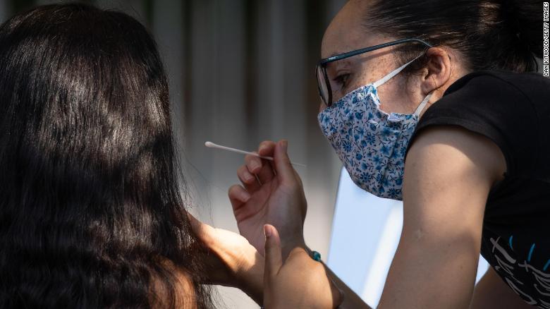A woman administers a swab test to a girl at a Covid test site in London, England, on September 15.