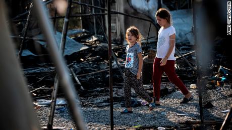 Two girls walk through the remains of the Moria refugee camp in Lesbos, Greece after it was destroyed by a fire in September 2020.