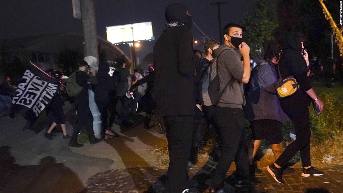 Demonstrators in Louisville react to gunfire. Two officers with the Louisville Metro Police Department were shot Wednesday night during the protests.