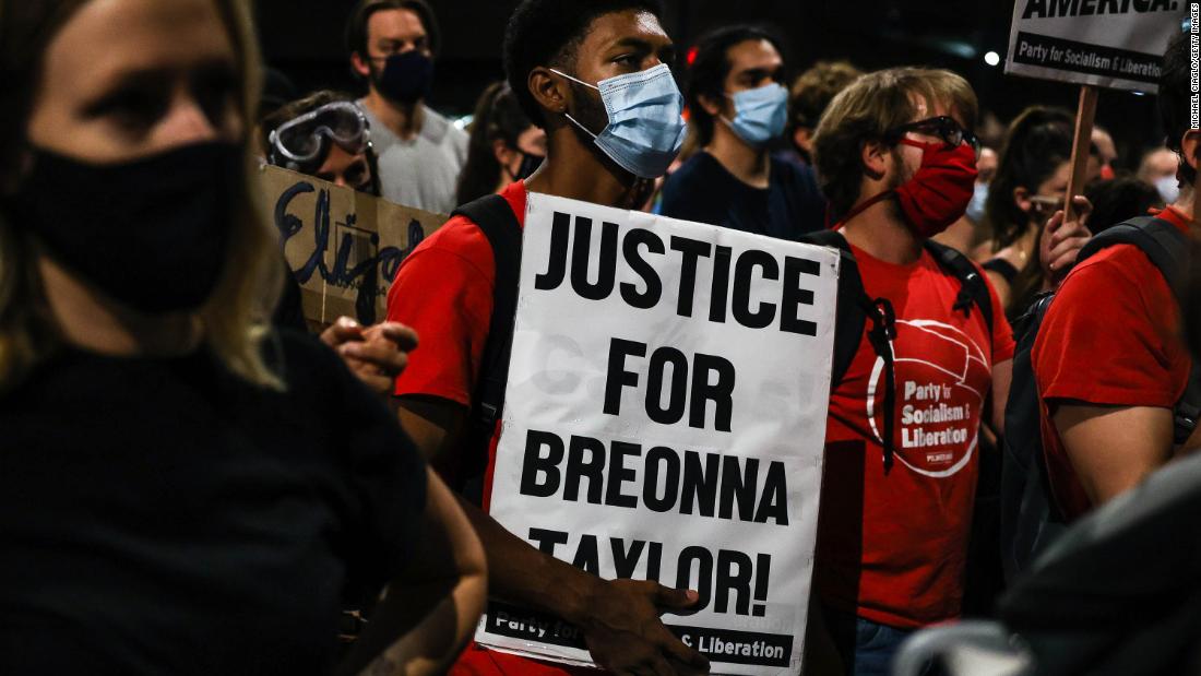 A man holds a sign reading &quot;Justice for Breonna Taylor&quot; in Denver.