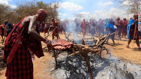 Maasai youth roast meat for the celebrants before attending the rites of passage initiation ceremony. The event was initially postponed due to the coronavirus disease outbreak in Maparasha hills of Kajiado, Kenya. 