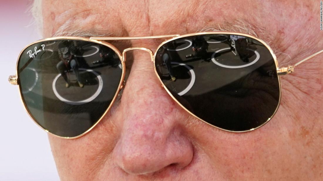 People sitting in social-distancing circles are reflected in Biden&#39;s sunglasses as he speaks in Charlotte, North Carolina.